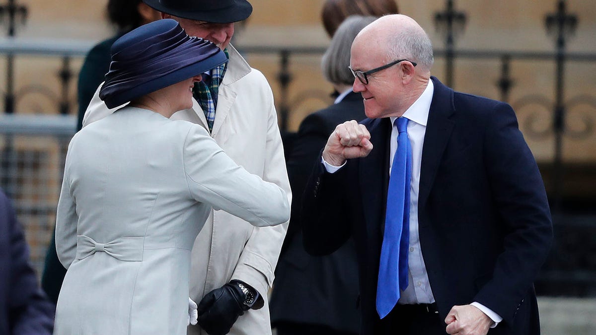United States Ambassador to the United Kingdom Woody Johnson, right, greets by bumping elbows as he arrives to attend the annual Commonwealth Day service at Westminster Abbey in London on Monday. (AP Photo/Frank Augstein)