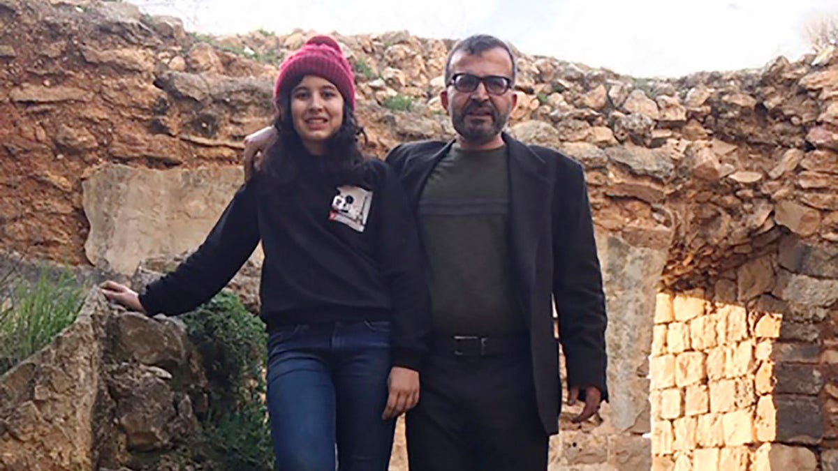 Ismail Mousa and his daughter Anisa of Selbyville, Del., pose for a photograph on March 12 while sightseeing near the Palestinian village of Qaryout in the West Bank. (Reem Mousa via AP)