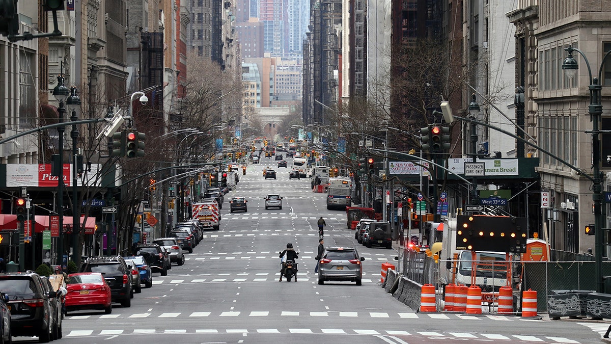 Vehicles wait at stoplights on a virtually empty 5th Avenue on Sunday in New York City. The "New York State on PAUSE" executive order, a 10-point policy to assure uniform safety for everyone was implented Sunday. (Gary Hershorn/Getty Images)