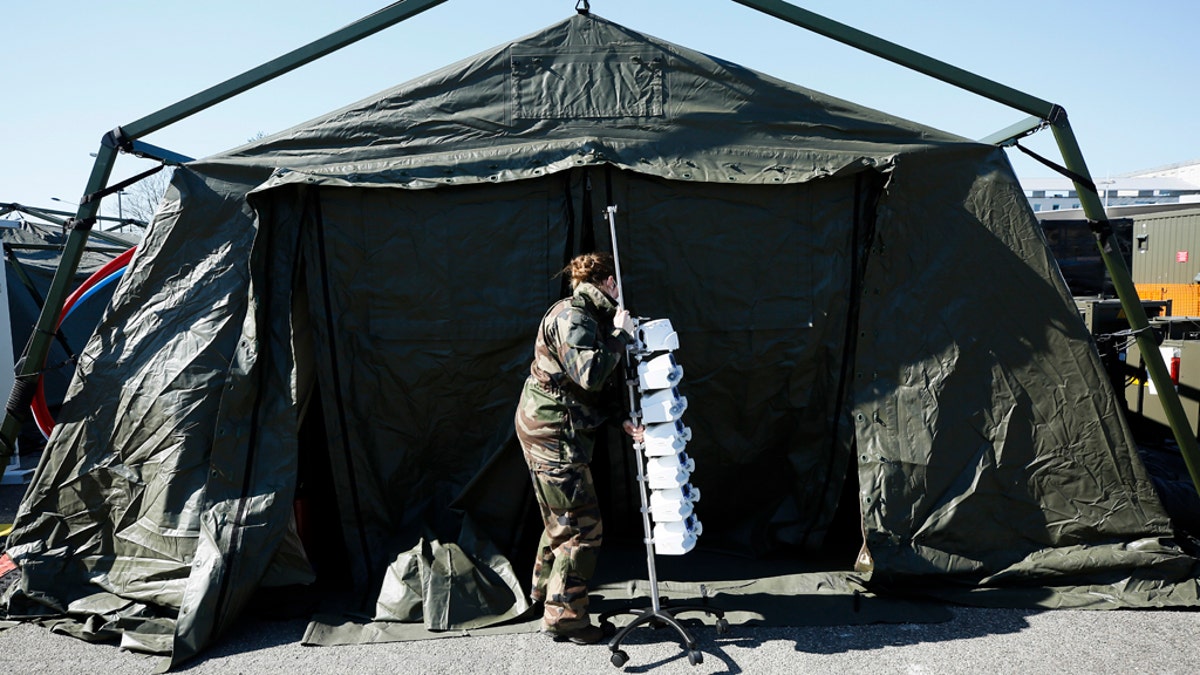 A French soldiers pulls medical gear at the military field hospital in Mulhouse on Tuesday after Macron ordered the facility built. (Mathieu Cugnot, Pool via AP)