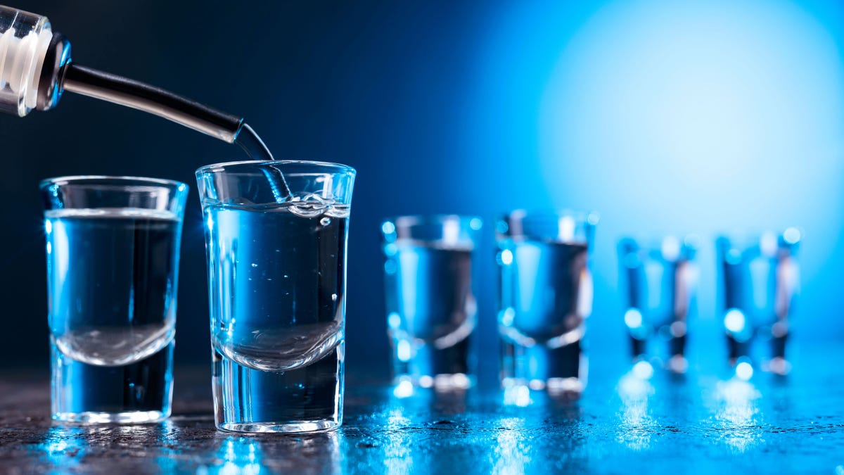 Vodka poured into a glass lit with blue backlight.