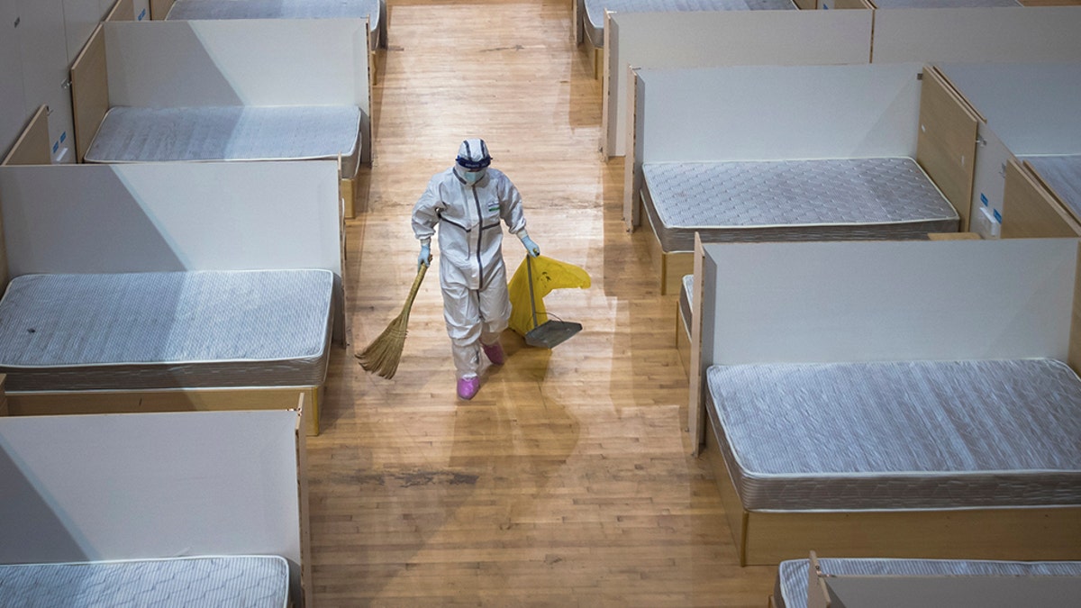 In this March 8, 2020, photo released by Xinhua News Agency, a staff member clean up an empty makeshift hospital in Wuhan, central China's Hubei Province.  (Xiao Yijiu/Xinhua via AP)