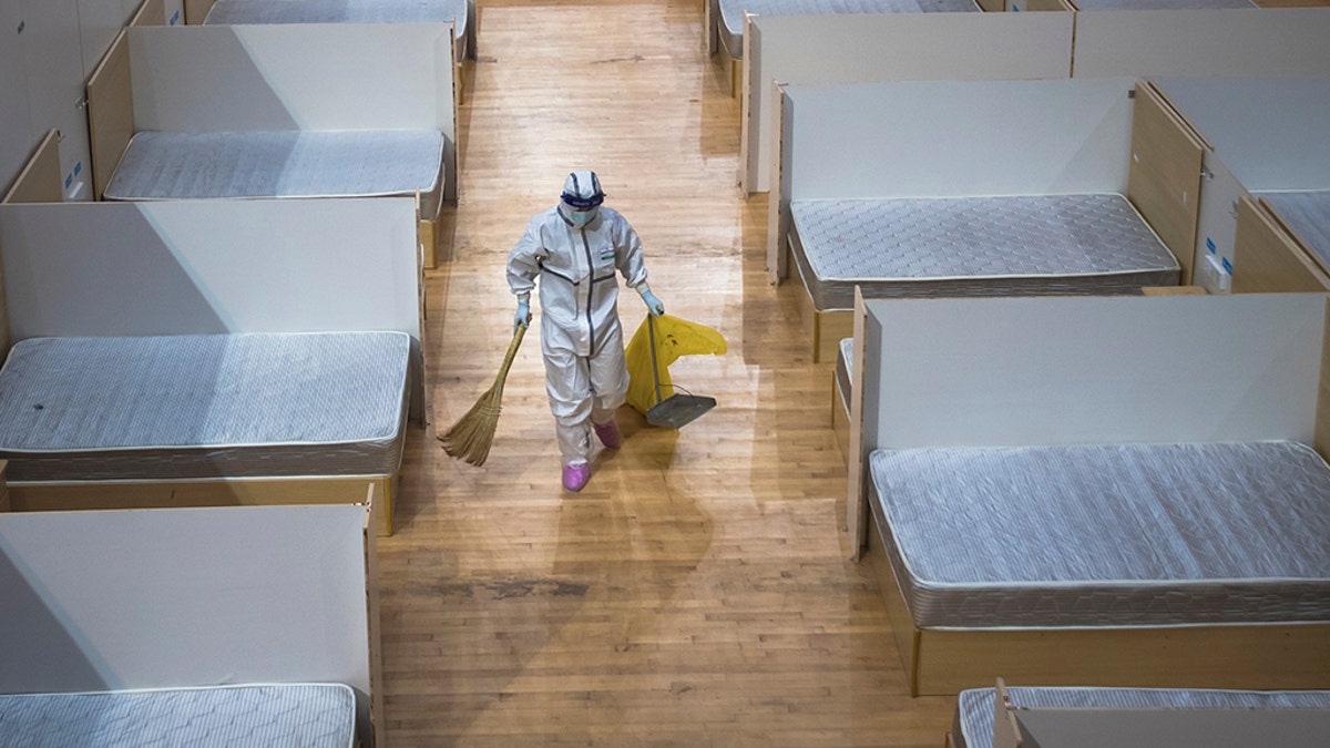 In this March 8, 2020, photo released by Xinhua News Agency, a staff member clean up an empty makeshift hospital in Wuhan, central China's Hubei Province.? (Xiao Yijiu/Xinhua via AP)