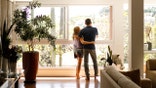 Couple admiring the view from the living room of their house.