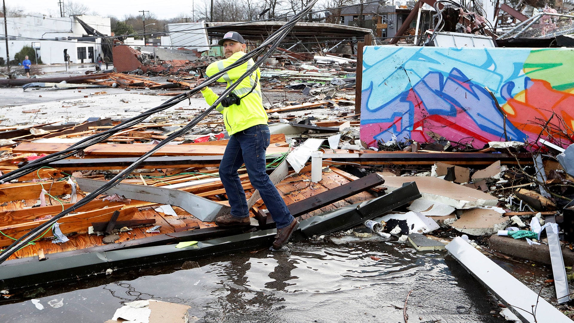 A man makes his way through debris following a deadly tornado in Nashville on Tuesday, March 3, 2020.
