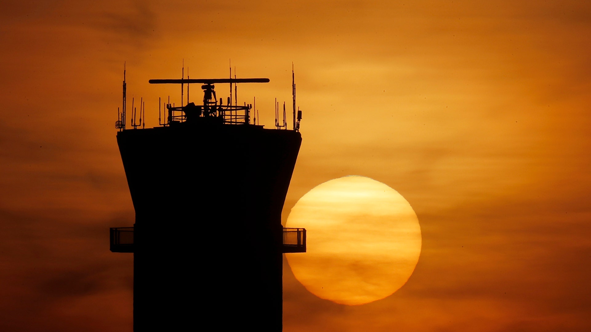 The sun sets behind the FAA Control Tower at Midway International Airport in Chicago, March 17, 2020. 