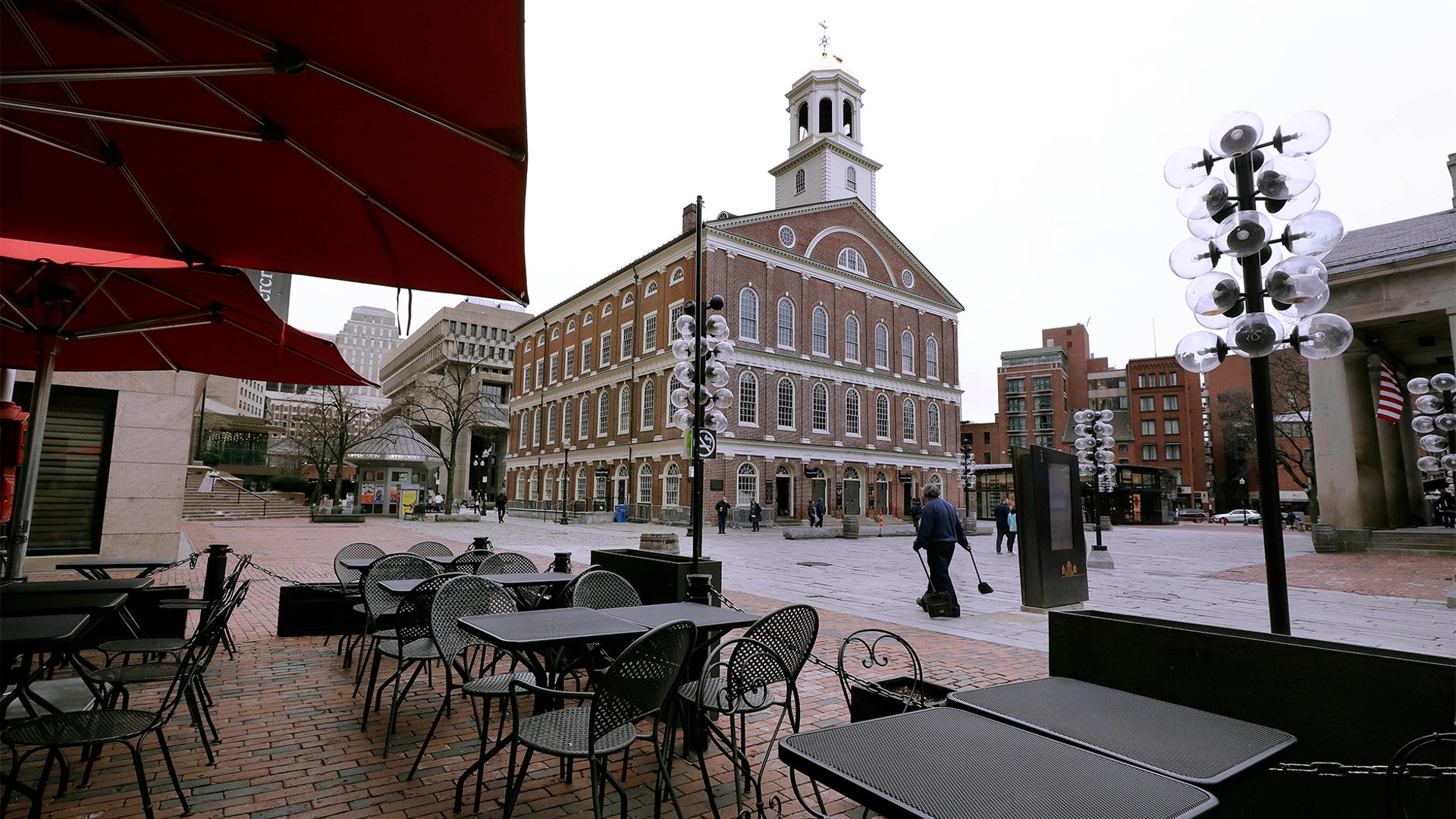 Tables are vacant in the nearly empty tourist area of Quincy Market in Boston, Mar. 11, 2020.