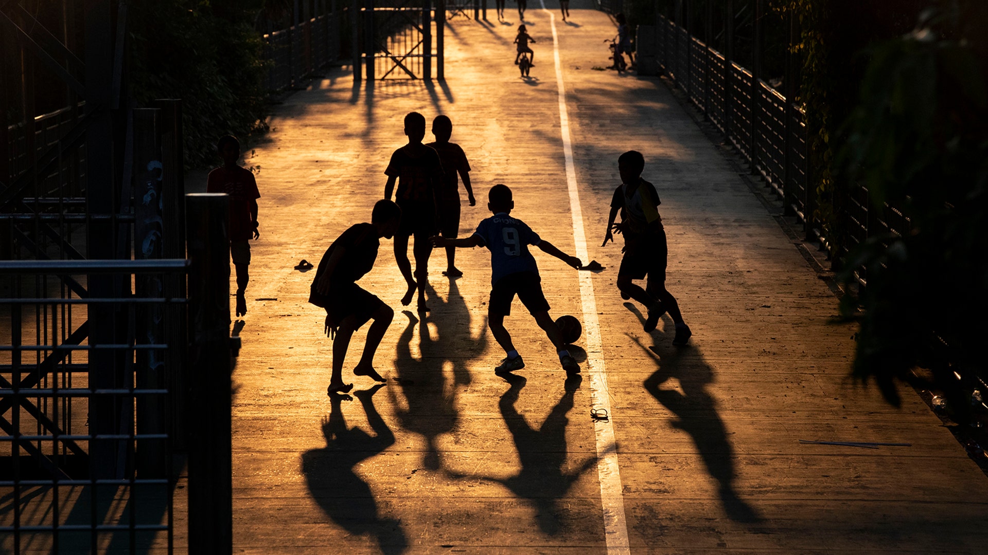Children play soccer in the afternoon light in Bangkok, Thailand, March 25, 2020. 