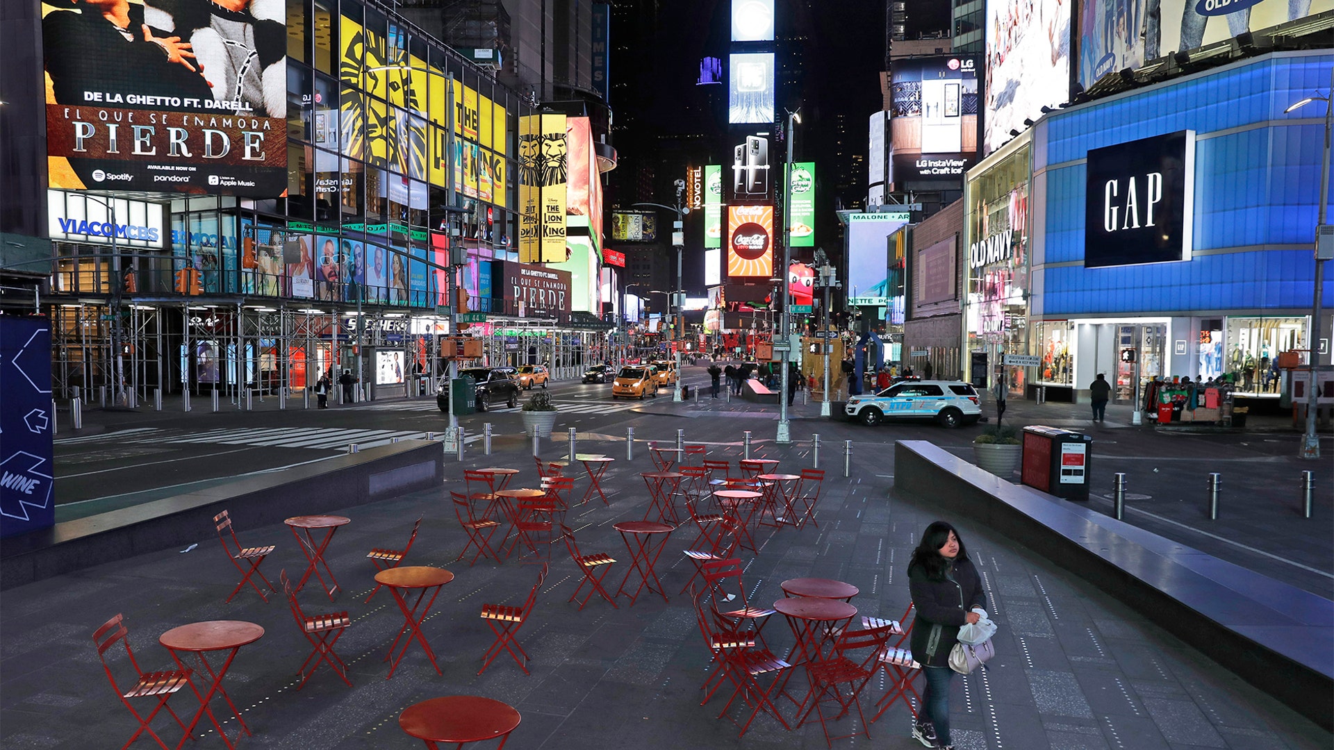 A woman walks through a lightly trafficked Times Square in New York, March 16, 2020.