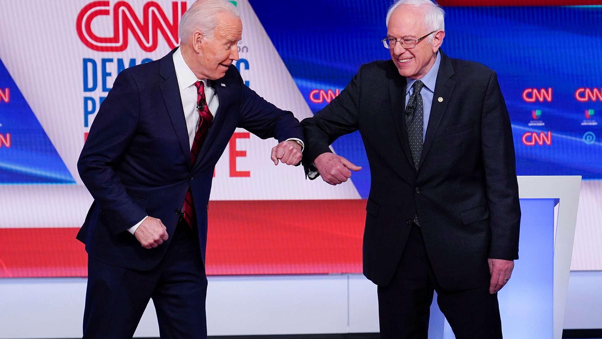 Former Vice President Joe Biden and Sen. Bernie Sanders greet one another before they participate in a Democratic presidential primary debate in Washington, March 15, 2020.