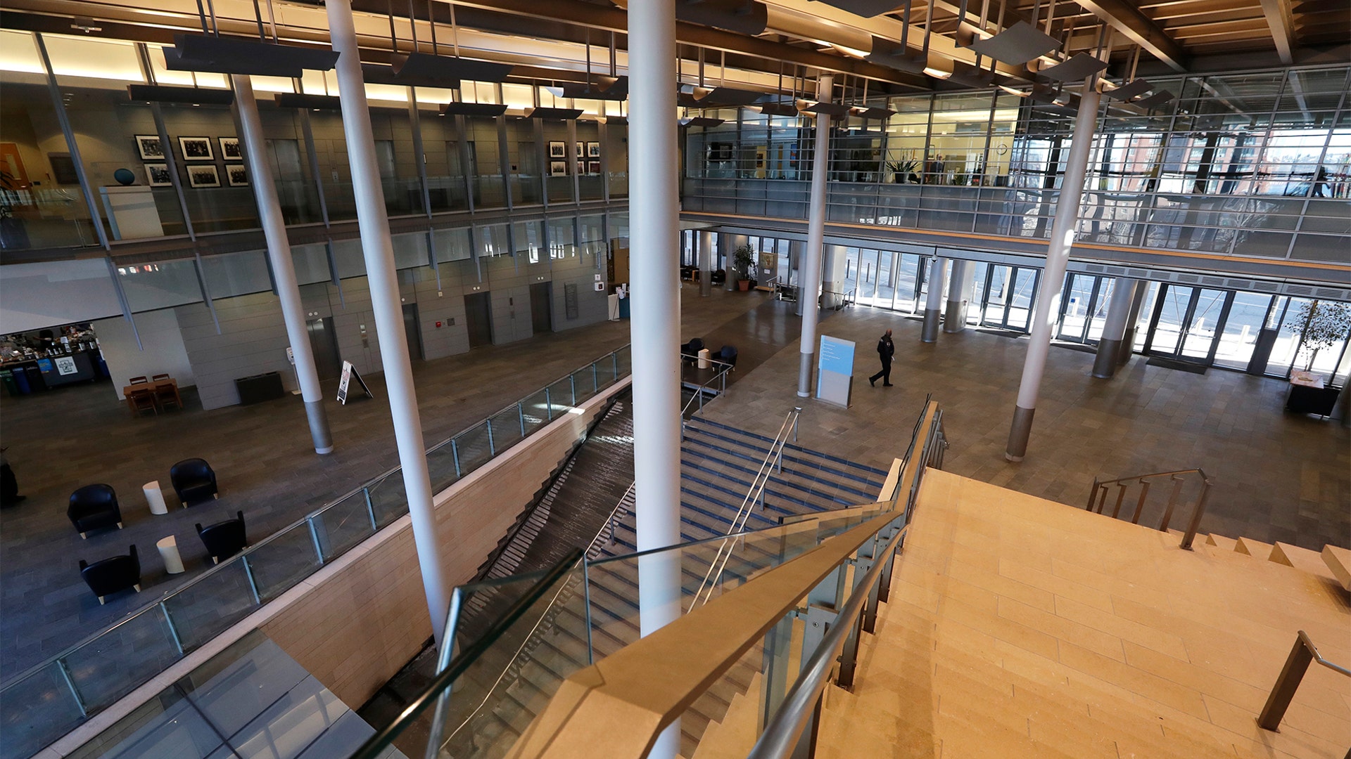 A lone security officer walks through an otherwise empty Seattle City Hall where most workers have been told to work from home in Seattle, March 16, 2020.
