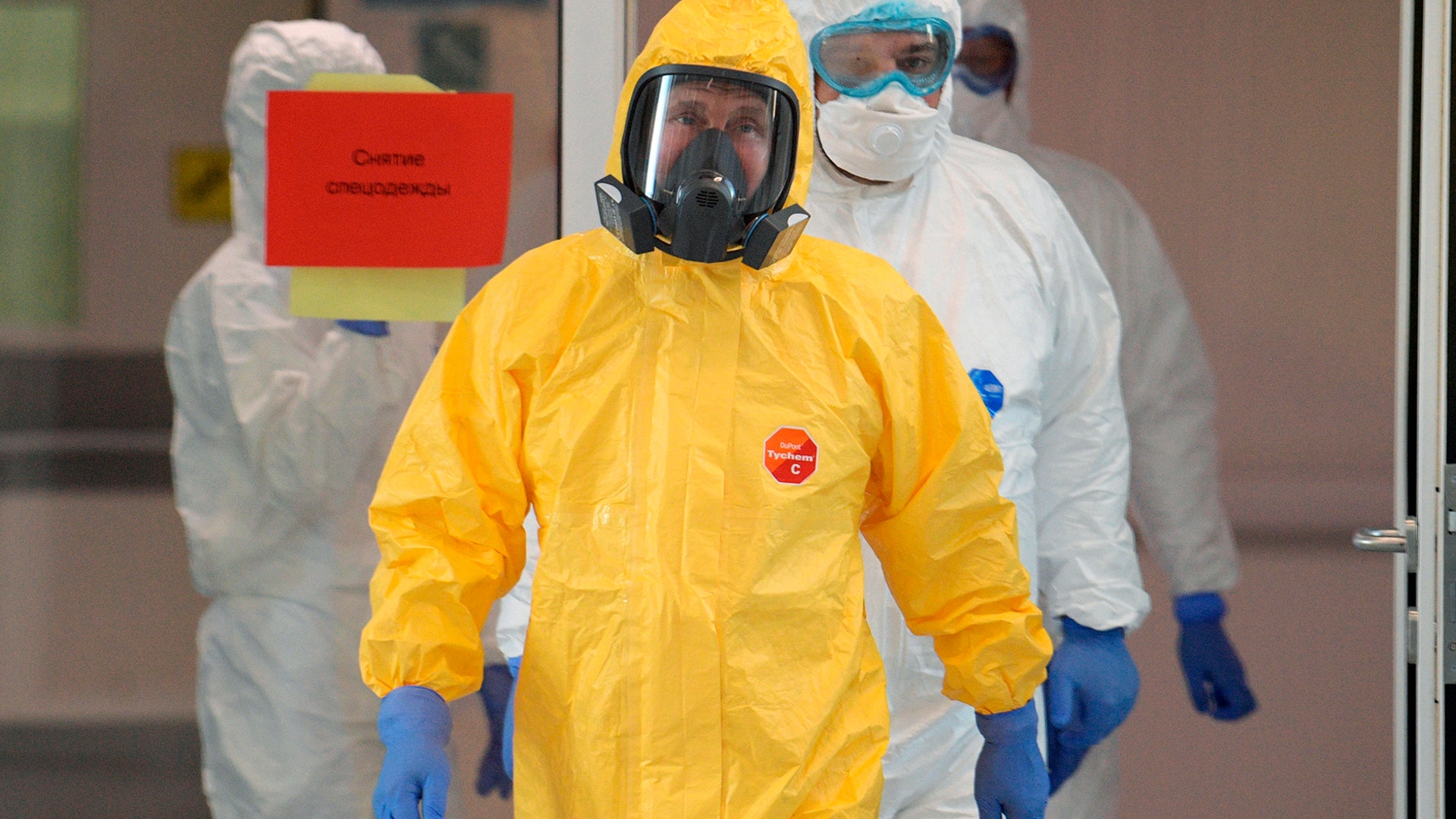 Russian President Vladimir Putin wearing a protective suit enters a hall during his visit to the hospital for coronavirus patients in Kommunarka settlement, outside Moscow, March 24, 2020.
