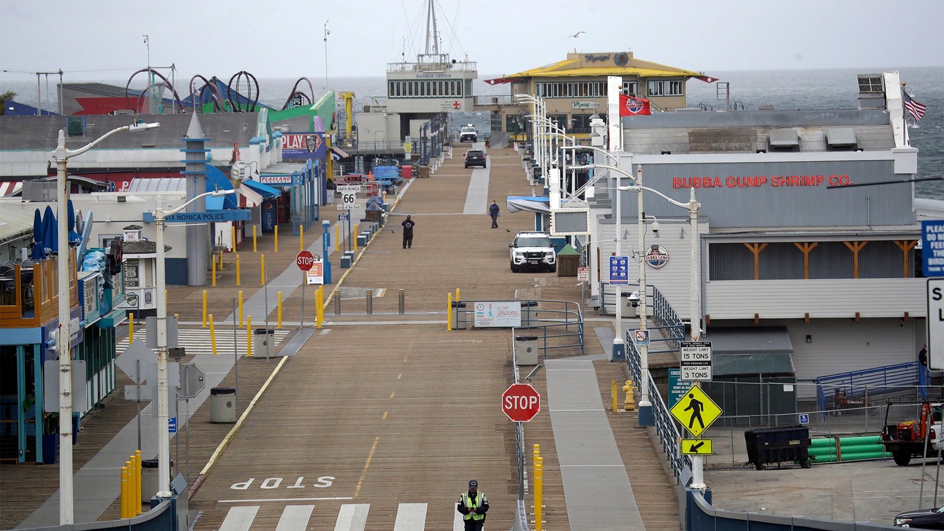 A police officer walks along the exit road at a near-empty Santa Monica Pier following a temporary closure as part of measures to combat the spread of the coronavirus in Los Angeles, March 16, 2020.