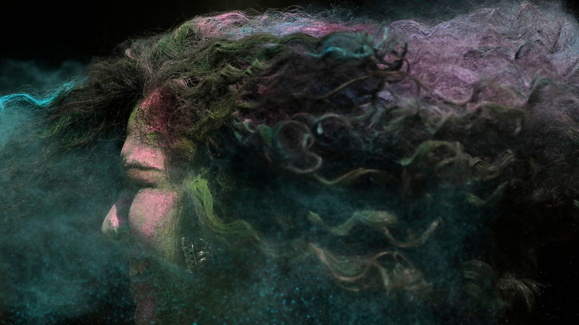 A woman's hair is smeared with colored powder during celebrations marking the Holi festival in Mumbai, India, March 10, 2020. 