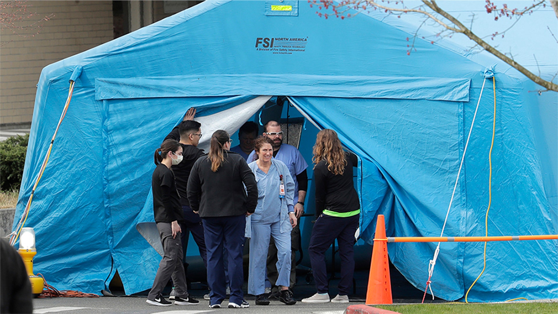 Workers exit a large tent set up in front of the emergency room at EvergreenHealth Medical Center in Kirkland, Wash., March 17, 2020.