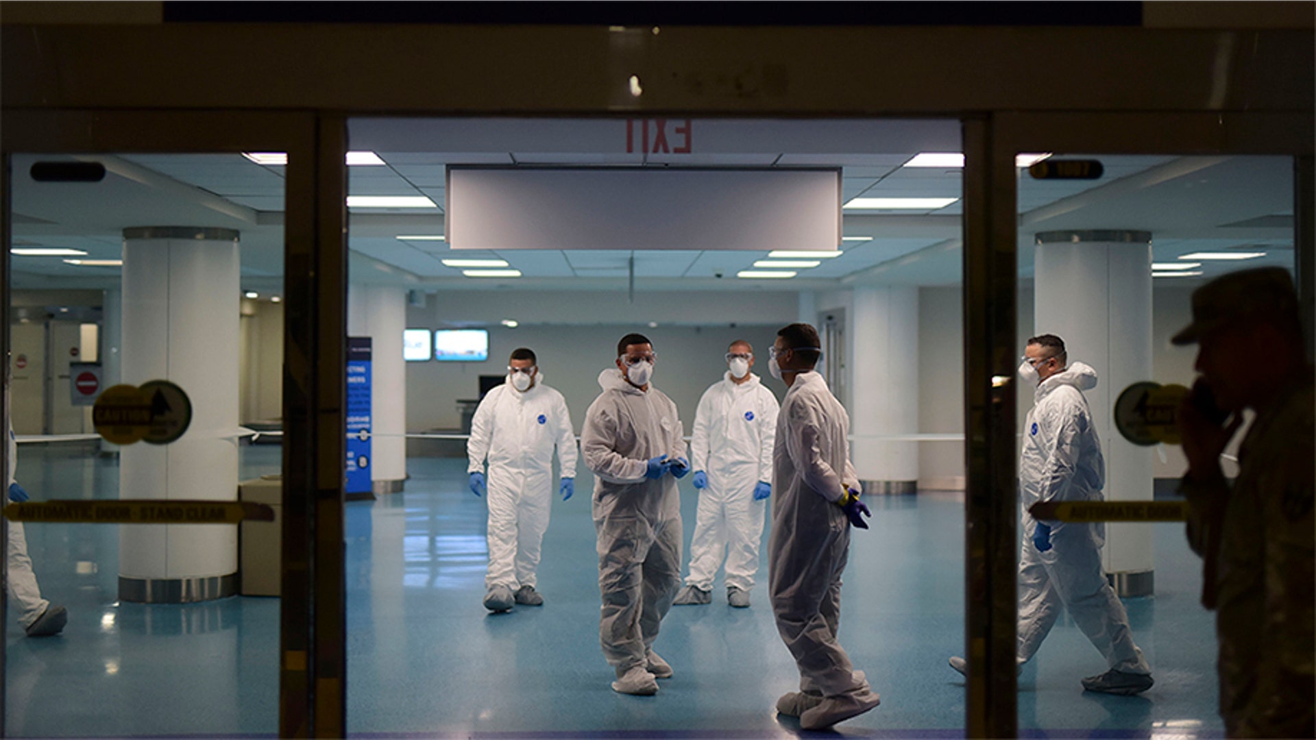 National Guard personnel who carry out bio screening on arriving passengers walk around the Luis Muoz Marin Airport in an effort to detect and isolate the new coronavirus, in Carolina, Puerto Rico, March 17, 2020.