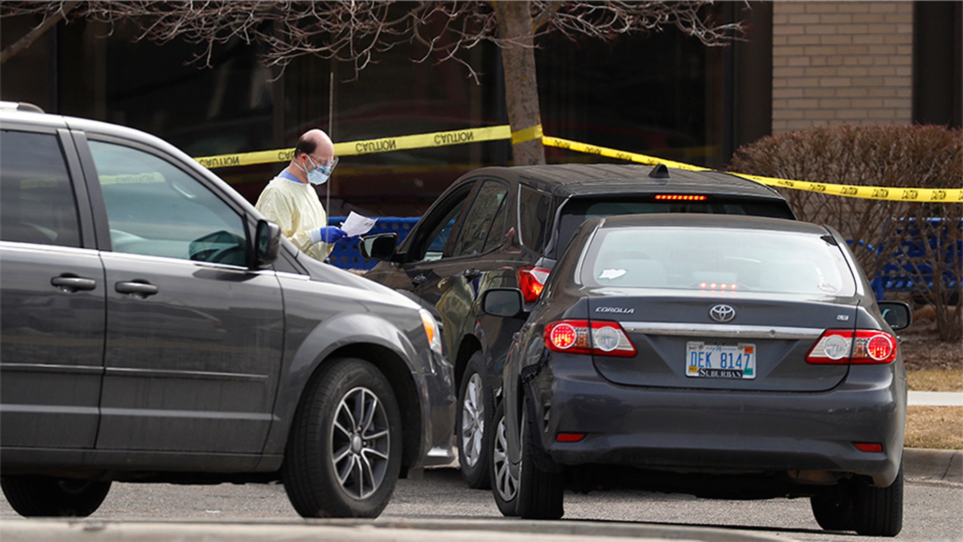 A health care worker screens people for COVID-19, the disease that is caused by the new coronavirus, at a drive-through station set up in the parking lot of the Beaumont Hospital in Royal Oak, Mich., March 16, 2020.