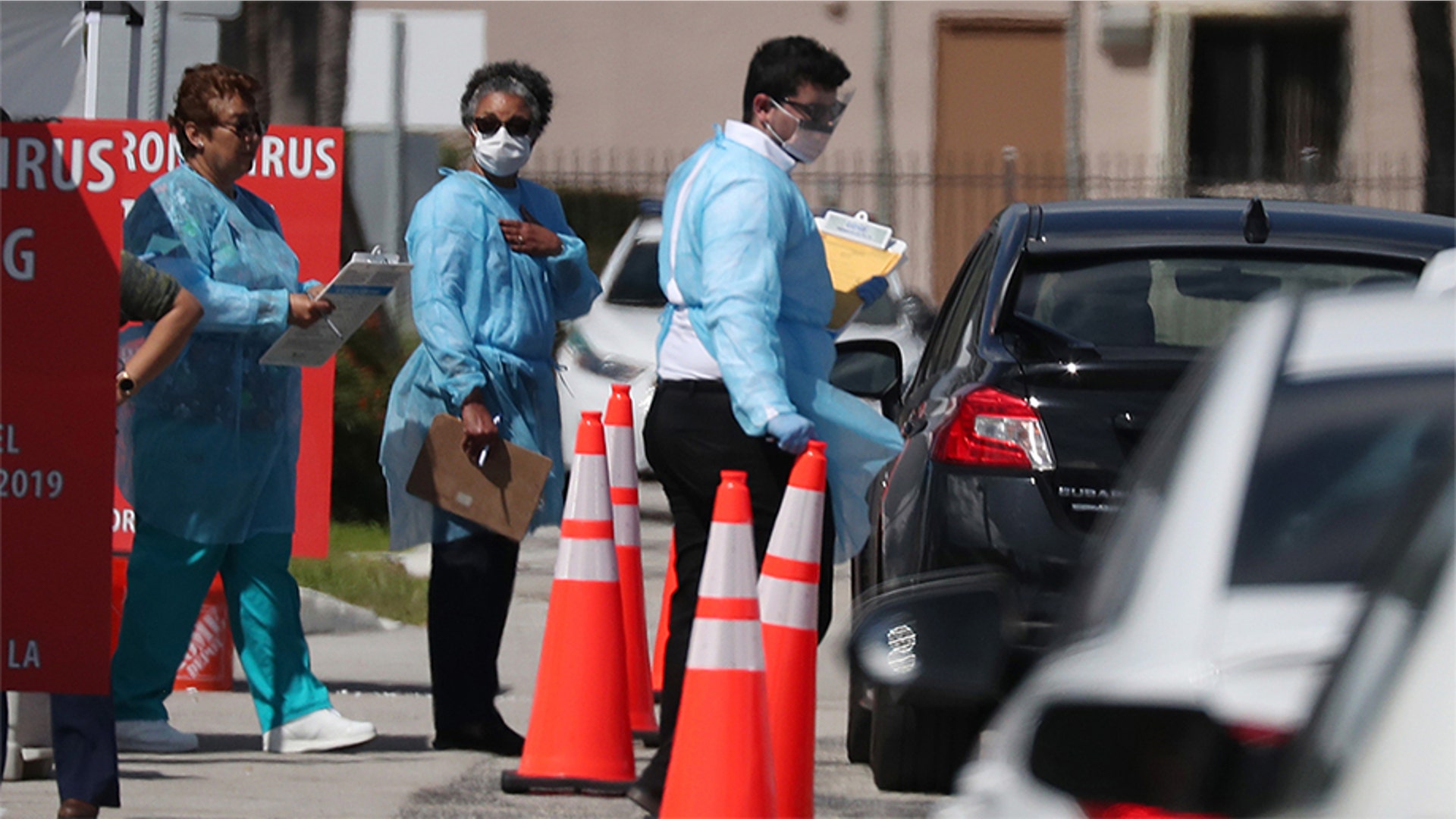 Health care staff from the Community Health of South Florida, Inc. (CHI) prepare to test people for the coronavirus in the parking lot of its Doris Ison Health Center in Miami, Fla., March 18, 2020.
