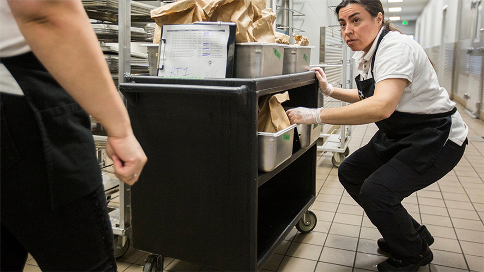 Ileana Koons organizes vegetable and meat options as the kitchen preps meals to get picked up and delivered to students in Bothell, Wash, March 12, 2020.
