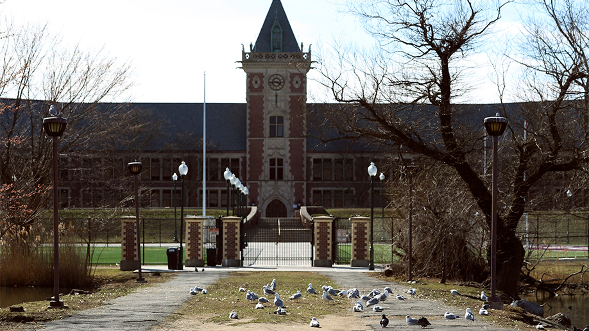 The front gate of New Rochelle High School. State officials on Tuesday called for closing schools, houses of worship and any other spaces where large numbers of people gathered within a 1-mile radius of a point near a synagogue where an infected person had attended events.