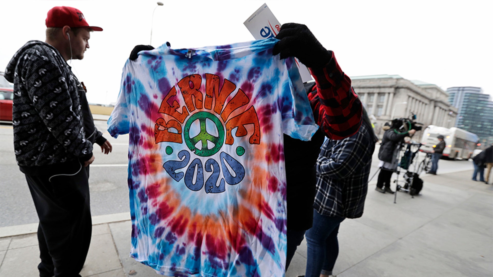 Jay Forbes selling shirts outside the Huntington Convention Center of Cleveland as a customer held up a Bernie 2020 shirt.