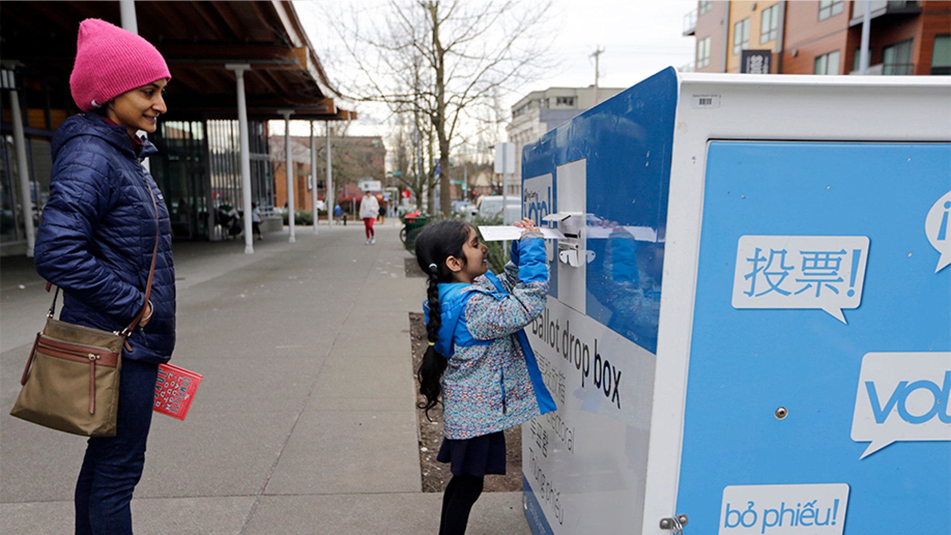 Gagan Thind watching as her daughter Seva dropped off ballots in the Washington State primary, in Seattle. Washington is a vote-by-mail state.