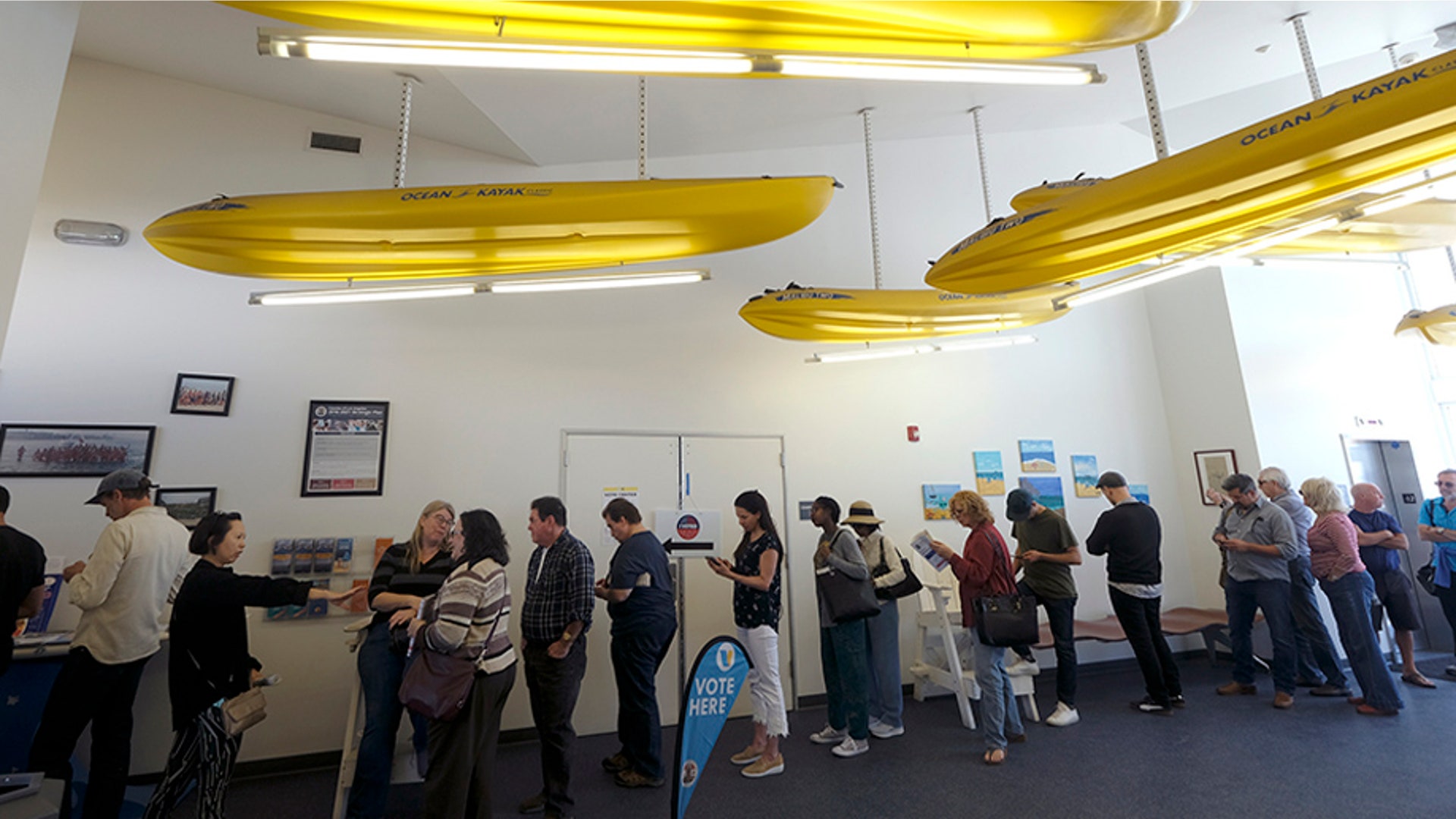 Voters wait in line to cast their ballots at a voting center in El Segundo, Calif.