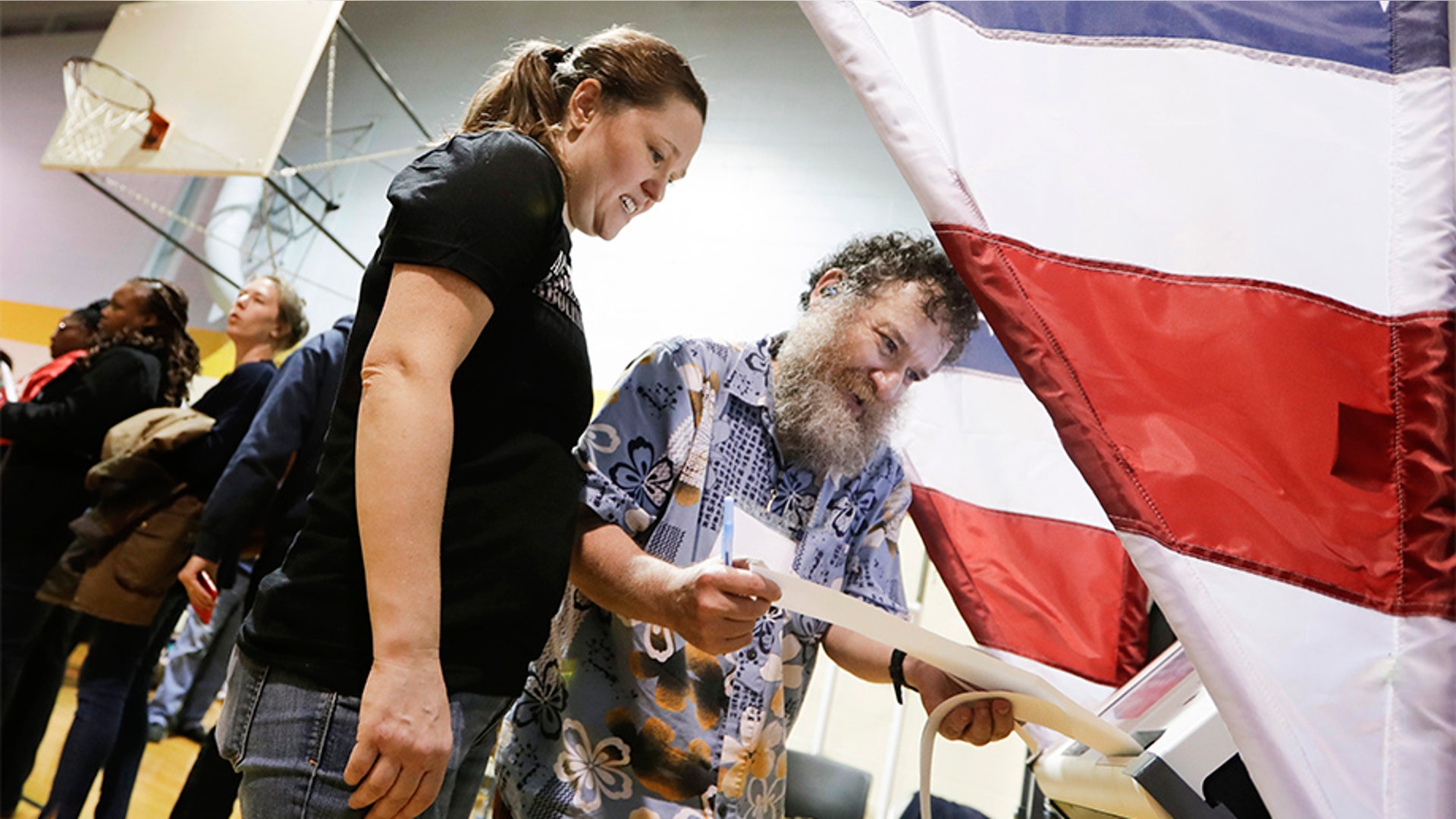 Voting machine operator David Schaefer, right, helps voter Kaitron Gordon with her ballot on Tennessee's Super Tuesday primary election at the Cleveland Park Community Center precinct. Super Tuesday polls stayed open late in Nashville after deadly overnight tornadoes delayed the start of voting in the city and rendered some of its polling places unusable. 