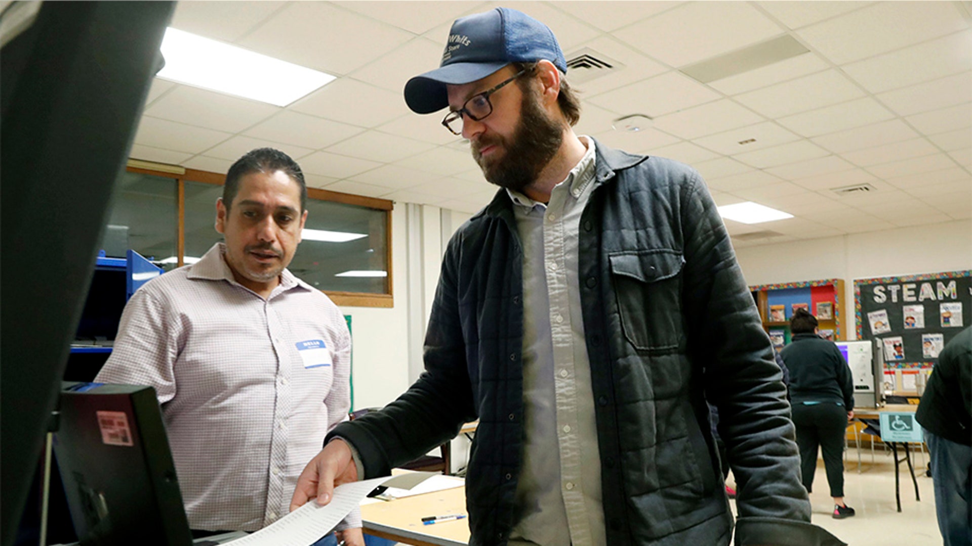 Dallas County election worker Maxx Nuñez helps Democrat Jamie Wilson cast his ballot in the Super Tuesday primary at John H. Reagan Elementary School in the Oak Cliff section of Dallas.