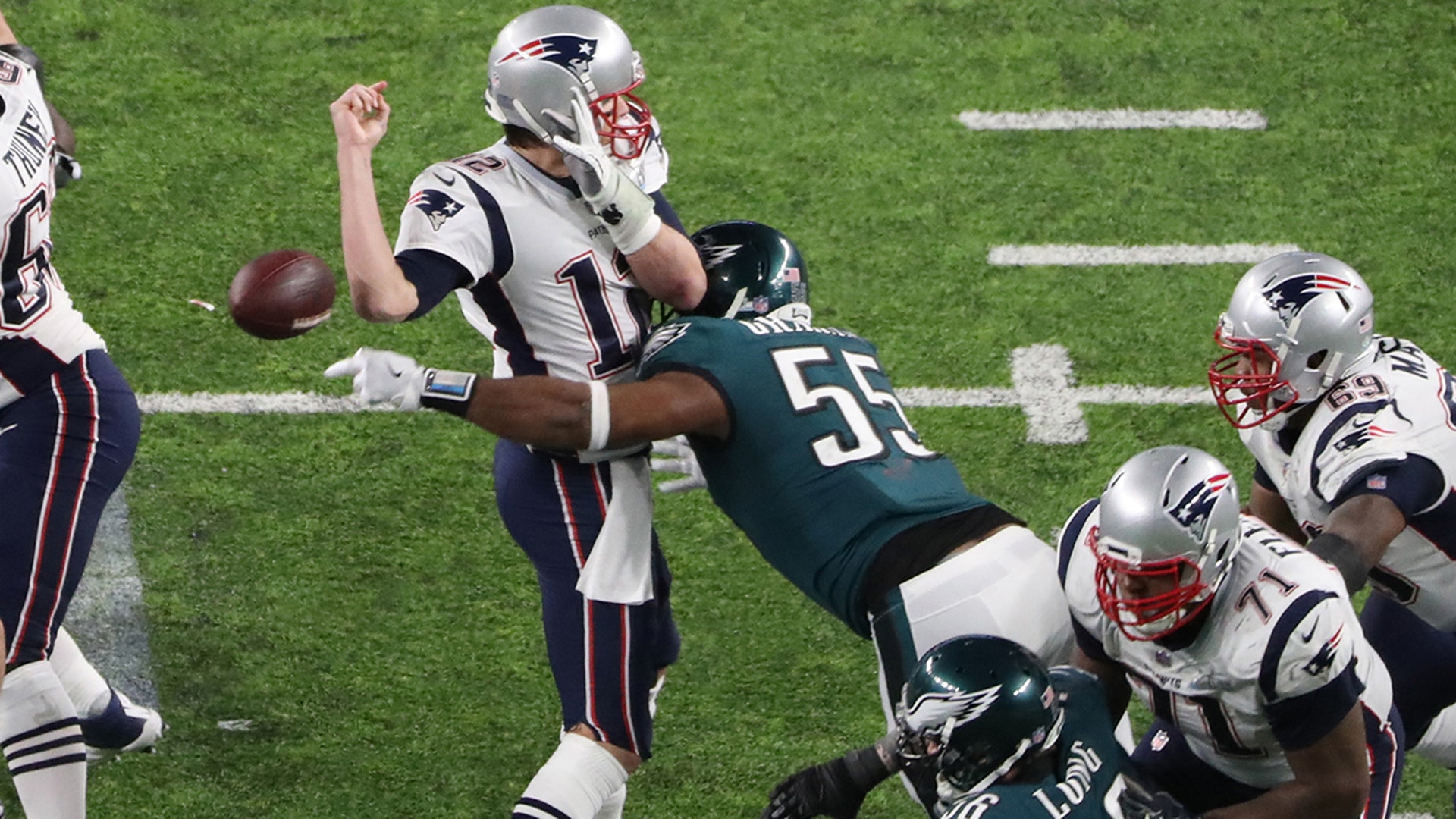 New England Patriots quarterback Tom Brady fumbles the ball as he is hit by Philadelphia Eagles defensive end Brandon Graham (55) during the fourth quarter in Super Bowl LII at U.S. Bank Stadium. 