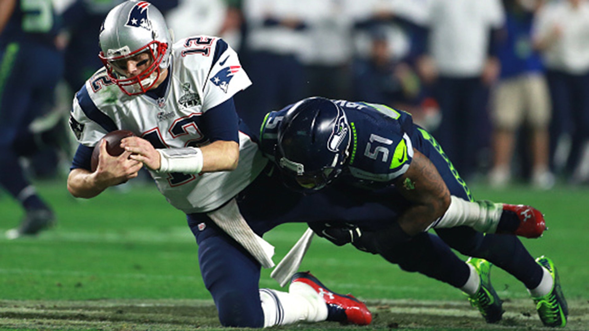 New England Patriots Tom Brady gets sacked by Seahawks Bruce Irvin in the fourth quarter. The New England Patriots plays against the Seattle Seahawks Sunday, Feb. 1, 2015.