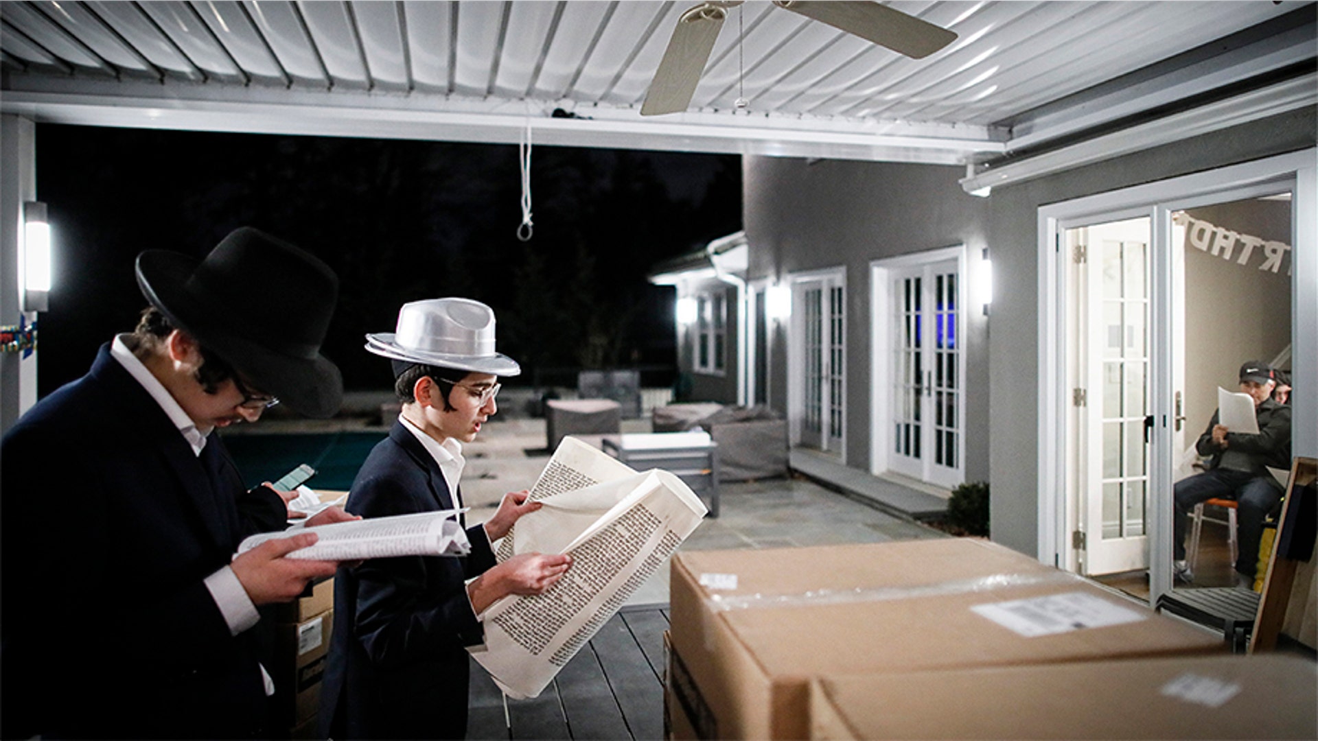 Yirmeyahu Gourarie performing a Purim reading from the Book of Esther for residents under self-quarantine due to potential exposure to the new coronavirus.