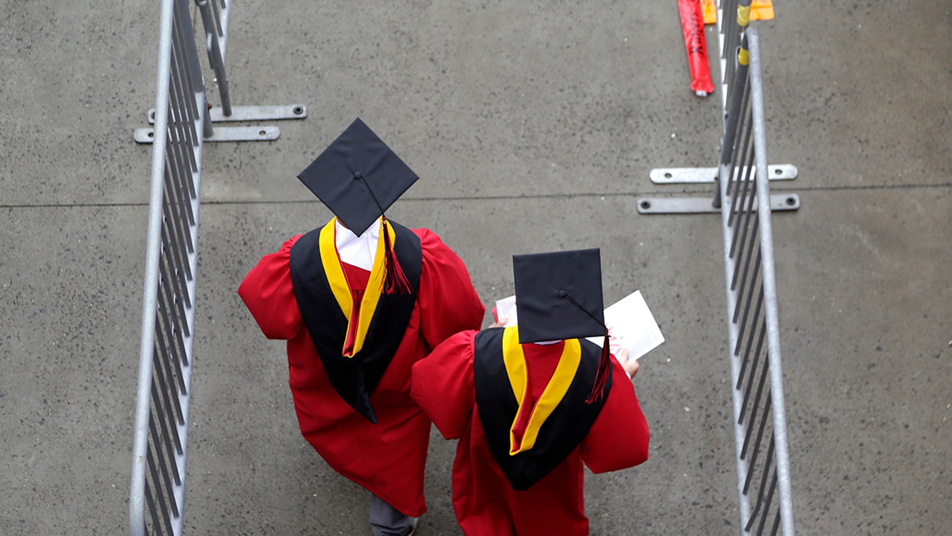 New graduates walk into the High Point Solutions Stadium before the start of the Rutgers University graduation ceremony in Piscataway Township, N.J. Colleges across the U.S. have begun cancelling and curtailing spring graduation events amid fears that the new coronavirus will not have subsided before the stretch of April and May when schools typically invite thousands of visitors to campus to honor graduating seniors.