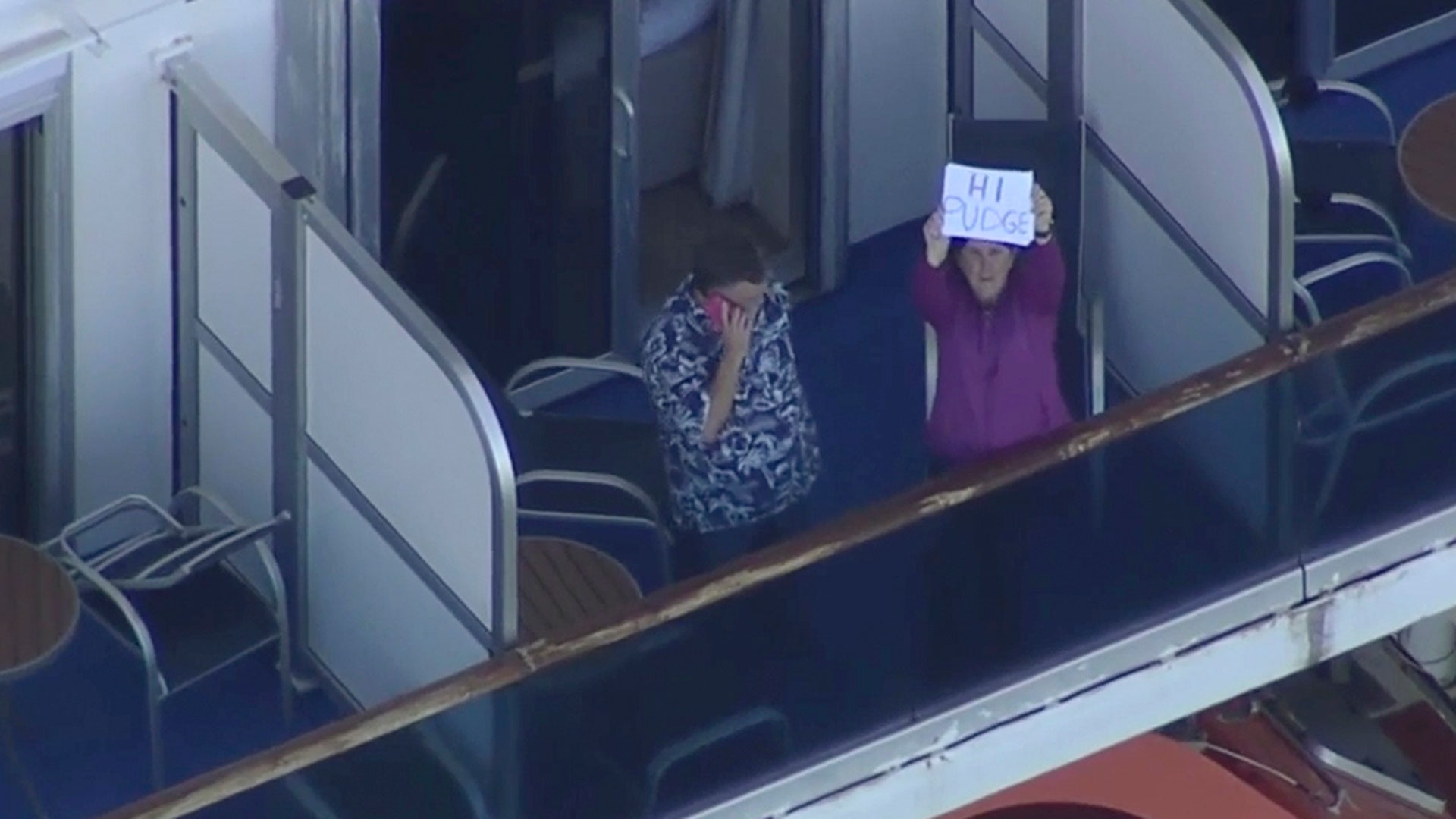 This photo taken from pool video provided by KGO-TV, shows a couple standing on their balcony of the Grand Princess cruise ship at the Port of Oakland, Tuesday, March 10, 2020, in Oakland, Calif. Thousands of increasingly bored and restless passengers aboard a cruise ship struck by the coronavirus waited for their turn Tuesday to get off the vessel and go into two weeks of quarantine at military bases around the U.S.