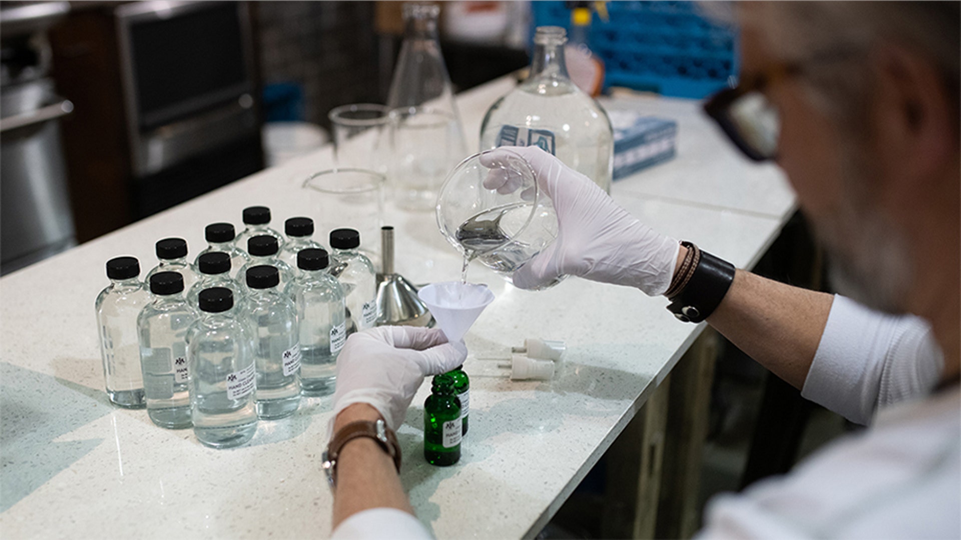 A worker fills a bottle with hand sanitizer solution made from distilled alcohol byproducts at the Glass Distillery in the SoDo neighborhood of Seattle, Wash., March 18, 2020.