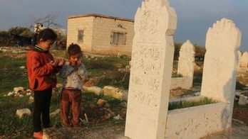 Displaced Syrian family lives in a graveyard as the war enters its 10th year