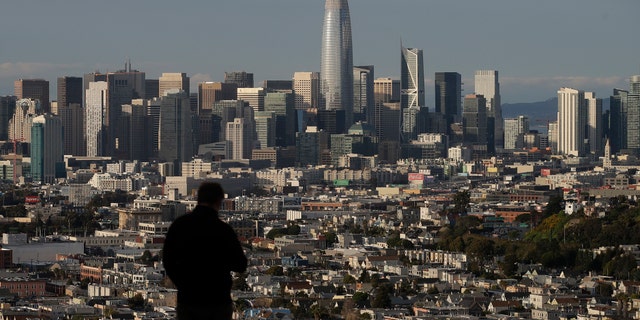 A man looks toward the skyline from Bernal Heights Hill in San Francisco, Monday, March 16, 2020. (AP Photo/Jeff Chiu)