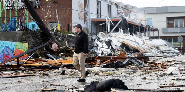 A man walks past storm debris following a deadly tornado Tuesday, March 3, 2020, in Nashville, Tenn.