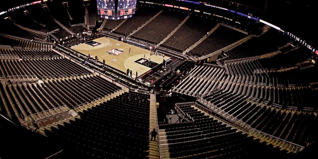 Big 12 commissioner Bob Bowlsby is seen on the big screen in an empty Sprint Center as he talks to the media after canceling the remaining games of the NCAA men's college basketball tournament due to concerns about the coronavirus Thursday, March 12, 2020, in Kansas City, Mo. (AP Photo/Charlie Riedel)
