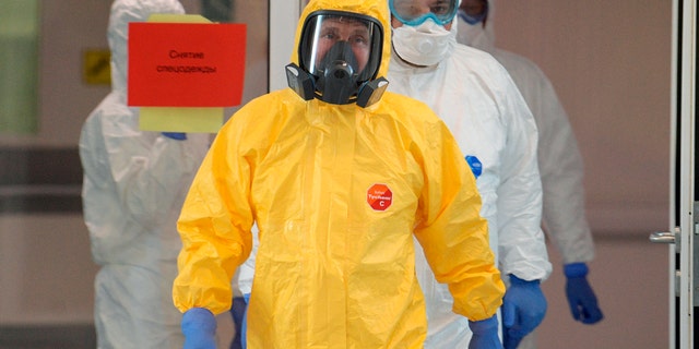 Russian President Vladimir Putin, center, wearing a protective suit as he entered a hall during his visit to a hospital for coronavirus patients in Kommunarka settlement, outside Moscow, last week. (Alexei Druzhinin, Sputnik, Kremlin Pool Photo via AP)