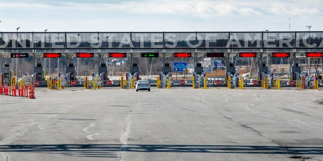 A vehicle approaches the only open lane at the United States border crossing in Lacolle, Quebec, Wednesday, March 18, 2020. (Ryan Remiorz/The Canadian Press via AP)