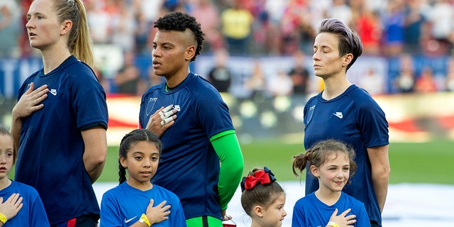 United States midfielder Samantha Mewis (3), goalkeeper Adrianna Franch, center, and forward Megan Rapinoe, right, stand with their jerseys turned inside out during the playing of the national anthem before a SheBelieves Cup women's soccer match against Japan, Wednesday, March 11, 2020 at Toyota Stadium in Frisco, Texas. (Associated Press)