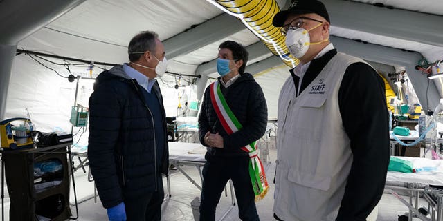 Lombardy Minister of Health Giulio Gallera, pictured left, and Cremona Mayor Gianluca Glamiberti, center, touring one of the eight tents that make up the medical facility.