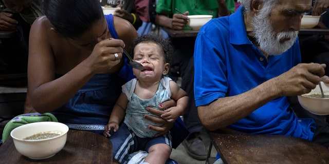 Zoraida Silva, 26, feeds her six month baby Jhon Angel, at a soup kitchen in The Cemetery slum, in Caracas, Venezuela. Silva said that she can not afford to have 3 meals a day, and she has been eating at the soup kitchen for two years ago. According to a survey recently published by the U.N. World Food Program, one of every three Venezuelans cope with food insecurity, unable to get enough food to meet their basic dietary needs. (AP Photo/Ariana Cubillos)