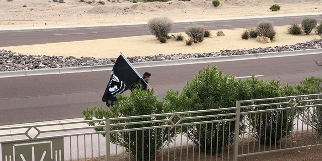 Airman David Saenz, 21, is seen holding Prinsoers of War flag while walking the streets of Las Cruces, N.M to honor the men who participated in the Bataan Death March during World War II.