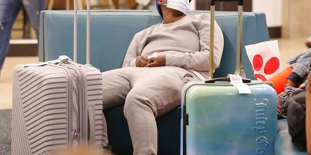 An airline passenger wears a mask in the terminal area of Orlando International Airport on Wednesday, March 4, 2020, in Orlando, Fla. Many travelers are wearing masks because of the coronavirus outbreak.