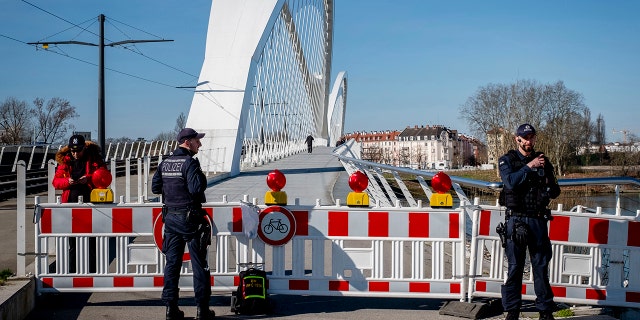 German police officers guard a closed bridge at the French/German border at the river Rhine in Kehl, Germany, Monday, March 16, 2020. German government allows only restricted access from France to Germany since Monday morning. (AP Photo/Michael Probst)