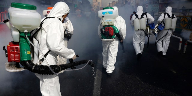 Firefighters disinfect a street against the new coronavirus in western Tehran on Friday as the virus continues to spread throughout the nation. (AP Photo/Vahid Salemi)