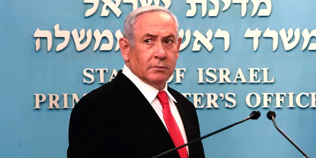 Prime Minister Benjamin Netanyahu approaches the podium to speak from his Jerusalem office on Saturday, March 14, 2020, saying Israel's restaurants and places of entertainment will be closed to stop the spread of the coronavirus. He also encouraged people not to go to their workplaces unless absolutely necessary. (Gali Tibbon/Pool via AP)