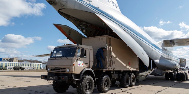 A military truck loads onto a Il-76 cargo plane in Chkalovsky military airport outside Moscow in preparation to deliver aid to Italy. (Alexei Yereshko, Russian Defense Ministry Press Service via AP)